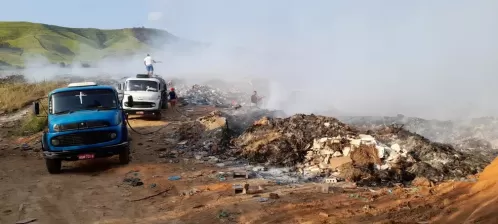 fumaça densa devido a fogo em lixão e pessoas trabalhando sem equipamento adequado